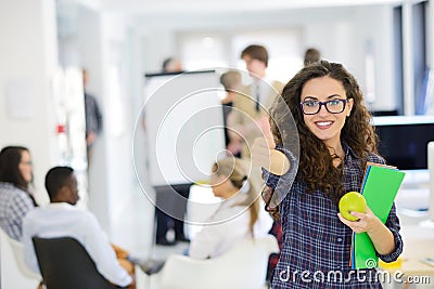 Business, startup and people concept - happy creative team with computer and folder in office Stock Photo