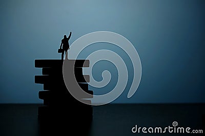 Business strategy conceptual photo - Silhouette of miniature businessman pointing upside above wooden staircase Stock Photo