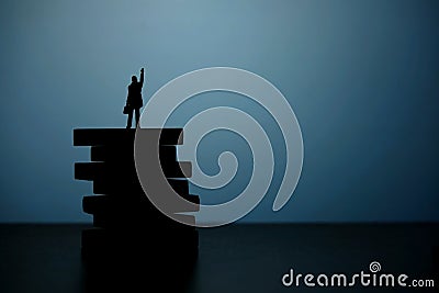 Business strategy conceptual photo - Silhouette of miniature businessman pointing upside above wooden staircase Stock Photo