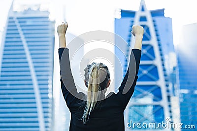 Business success - Celebrating businesswoman overlooking the city center high-rises Stock Photo