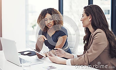 Business success is what theyre best at. two businesswomen using a digital tablet together during a collaboration at Stock Photo