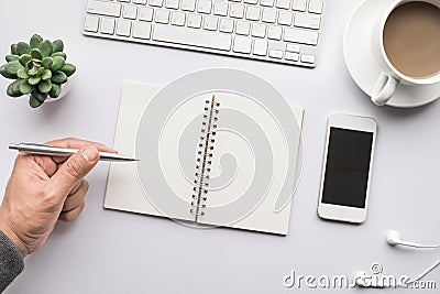 Business table top with mock up office supplies and male hand on white background.Flat lay design. Stock Photo