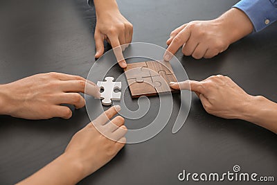 Business team assembling puzzle on dark table. Difference concept Stock Photo