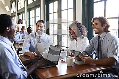 Business Team Having Informal Meeting Around Table In Coffee Shop Stock Photo