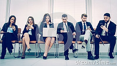 Business team with laptop and smartphone sitting on the sofa in Stock Photo