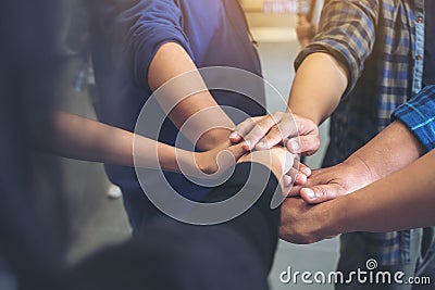 Business team standing and joining their hands together in office Stock Photo