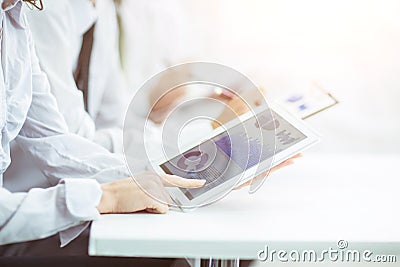 Business team using digital tablet performs analysis of marketing graphics Stock Photo