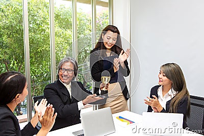 Business team winning trophy in the office . Businessman with teamwork in award and successful showing trophy and rewarded for in Stock Photo