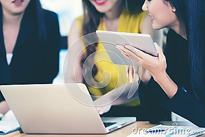 Business team work women partners discussing graph of financial in work space. Asian women using tablet for connection technolog Stock Photo