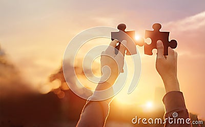 Business of teamwork, symbol of success, jigsaw puzzle in hand connecting, business planning and strategy on sunset Stock Photo