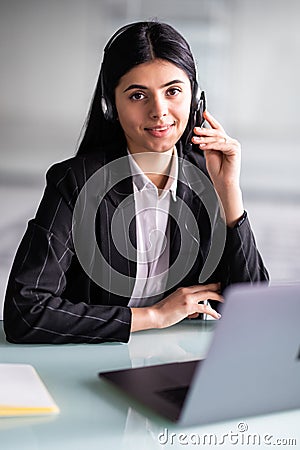 Business, technology and communication concept. Young female helpline operator in headset working at office Stock Photo