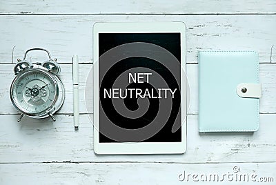 Business and technology concept. Top view of clock,pen,notebook and tablet written with Net Neutrality on white wooden background. Stock Photo