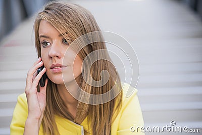 Business, technology and people concept - serious businesswoman with smartphone talking over office building. Stock Photo