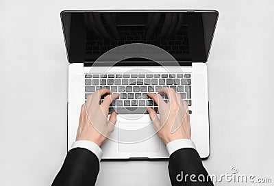 Business and technology topic: the hand of man in a black suit showing gesture against a gray and white background laptop in the s Stock Photo