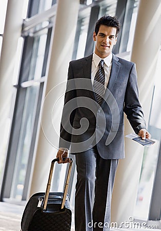 Business traveler pulling suitcase and passport Stock Photo