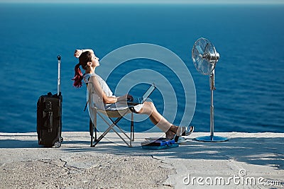 Business travelling, life work balance concept. Woman working on laptop and relaxing on seashore. Lifestyle change idea. Stock Photo