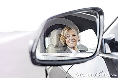 Portrait of businessman reflecting in side-view mirror of car Stock Photo