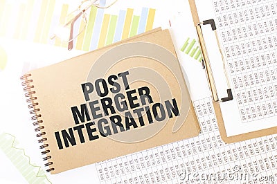 Business up graph on a sheet of craft colour Notepad with POST MERGER INTEGRATION sign. Notepad on desk with financial Stock Photo