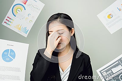 Business woman in a black suit is throw away a lot of paperwork and the documents are blown overhead. showing signs of stress. Stock Photo