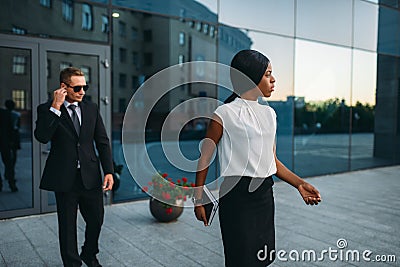 Business woman, bodyguard in suit on background Stock Photo