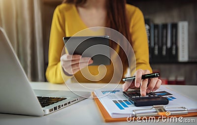 Business woman calculates financials with graph paper on the table on the cost of home office. Stock Photo