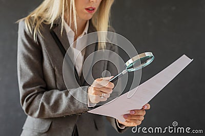 Woman carefully reading business contract with magnifying glass Stock Photo