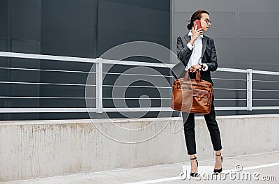 A business woman checks the time in the city during a working day waiting for a meeting. Discipline and timing. An employee goes Stock Photo