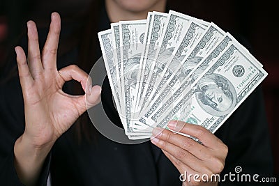 Business woman displaying a spread of cash over, spending money or profit from business operations concept Stock Photo