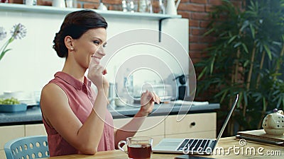 Business woman finishing work on laptop. Young girl drinking tea at home. Stock Photo