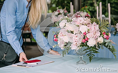 Business woman florist decorates table notepad smartphone Stock Photo