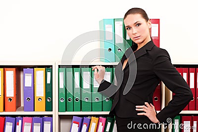 Business woman in front of shelves with folders Stock Photo