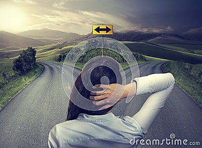 Business woman in front of two roads thinking deciding Stock Photo