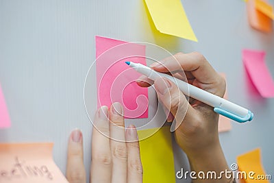 Business woman hand writing with colored sheets sticky note paper on white board background Stock Photo