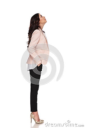 Business woman with hands in pockets looks up Stock Photo