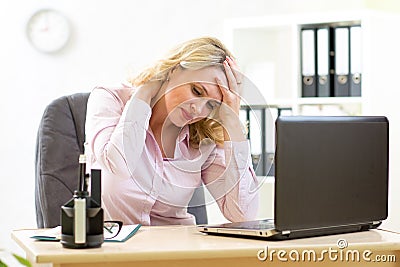 Business woman with headache having stress in the office Stock Photo