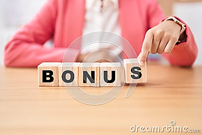 Business woman holding cubes with bonus word on the table Stock Photo