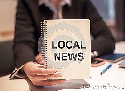 Business woman holds a notebook with the text LOCAL NEWS Stock Photo