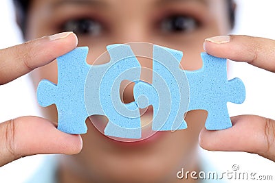 Business woman joining two jigsaw puzzle pieces Stock Photo