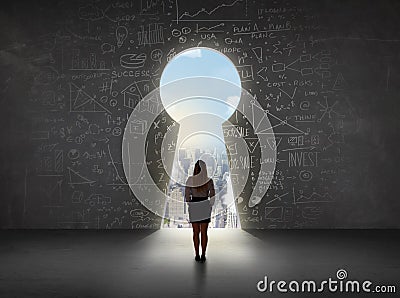 Business woman looking at keyhole with bright cityscape concept Stock Photo