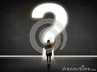 Business woman looking at wall with a bright question mark Stock Photo