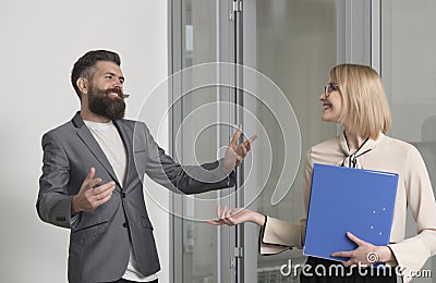 Business woman and man colleagues in office. Bearded man talk to sensual woman with binder. Office workers wear formal Stock Photo