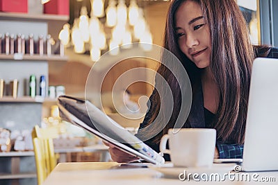 A business woman reading newspaper and drinking coffee in the morning Stock Photo