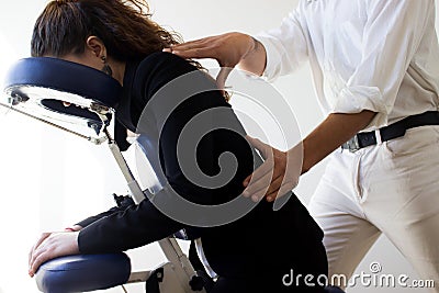 Business woman receiving shiatsu on a massage chair Stock Photo