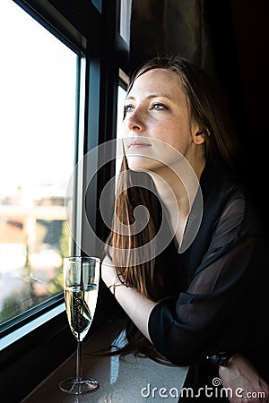 Business woman resting at the window with a glass of champaign Stock Photo