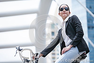 Business woman riding bicycle to work on urban street .transport and healthy . fashion lifestyle cool smart Stock Photo
