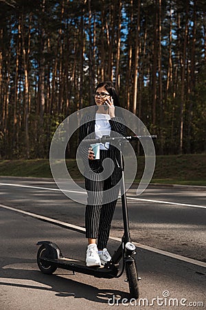 Business woman riding electric scooter at parking lot - Emission free eco friendly transportation Stock Photo