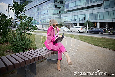 Business woman sitting on a bench in the street Stock Photo