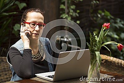 Business woman sitting with laptop at table in a cafe. Talking. Stock Photo