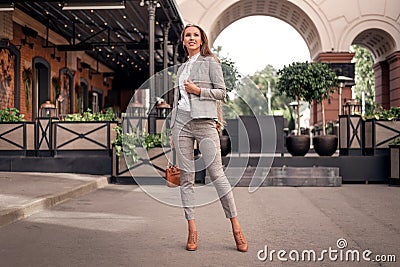 Business woman in a stylish suit in a cage walks down the street. model posing in lightweight outfit Stock Photo