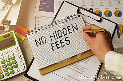 Business woman, at the table in the office, makes notes in a notebook. The inscription in NO HIDDEN FEES. Desktop view along with Stock Photo